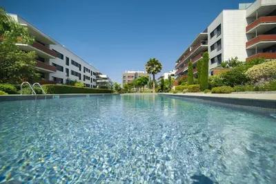 a swimming pool in front of some apartment buildings at Luxury Apartment in Sitges City in Sitges
