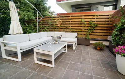 a patio with a white couch and a table and an umbrella at Luxury Apartment in Sitges City in Sitges