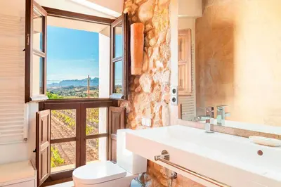 a bathroom with a sink and a toilet and a window at Masia Can Canyes & Spa in San Lorenzo de Hortóns