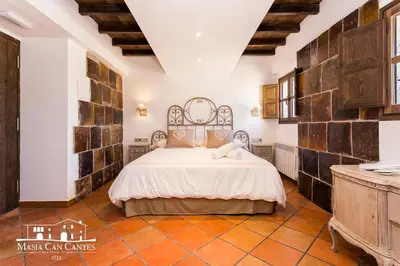 a bedroom with a bed in a room at Masia Can Canyes & Spa in San Lorenzo de Hortóns