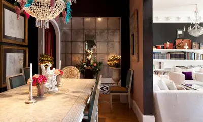 a dining room with a table with flowers on it at HoHomes - Luxury Palacete in Barcelona