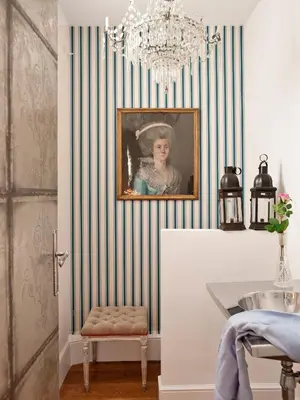 a room with a painting of a woman on a striped wall at HoHomes - Luxury Palacete in Barcelona