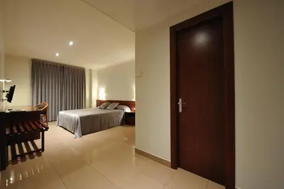 a bedroom with a bed and a desk and a door at Hotel Els Noguers in Manresa