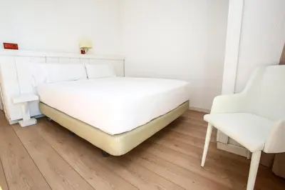 a bed and a chair in a room at Solvi Hotel - Adults Only in Vilanova i la Geltrú