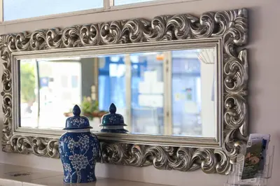 a mirror and a blue and white vase in front of a mirror at Solvi Hotel - Adults Only in Vilanova i la Geltrú