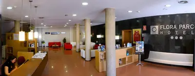a woman sitting at a counter in a store at Hotel Flora Parc in Castelldefels