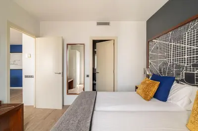 a bedroom with a large white bed with blue pillows at Naitly Barcelona Poblenou in Barcelona