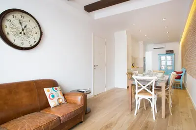 a living room with a couch and a clock on the wall at Sweet Home Sitges BY BLAUSITGES in Sitges