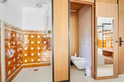 a bathroom with a toilet and a glass door at Le Palacete by Sweett in Barcelona