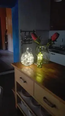 a kitchen counter with two glass jars and flowers on it at El Terral in Sant Vicenç de Montalt