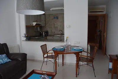 a living room with a table and chairs and a kitchen at Apartamento Flavia I Espalter in Sitges