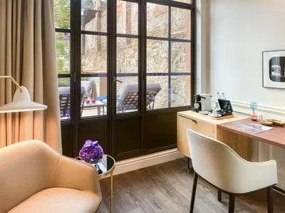 a room with a desk and chairs and a window at H10 Casa Mimosa 4* Sup in Barcelona