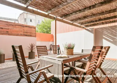 a patio with a wooden table and chairs at Inside Barcelona Apartments Princep in Barcelona