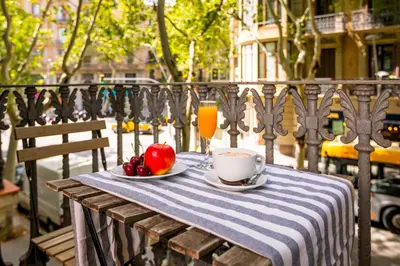 a table with a bowl of fruit and a cup of coffee at Mayerling Schumann Barcelona in Barcelona
