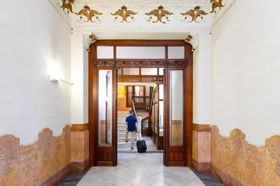 a person with a suitcase walking through an open door at Mayerling Schumann Barcelona in Barcelona