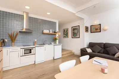 a kitchen and living room with a couch and a table at Mayerling Bisbe Urquinaona in Barcelona