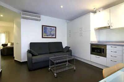a living room with a couch and a kitchen at Classbedroom Born Apartments in Barcelona