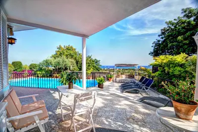 a patio with a table and chairs and a swimming pool at Can Ferran by Hello Homes Sitges in Sitges