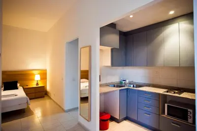a kitchen with blue cabinets and a bed in a room at Ramblas Apartments in Barcelona