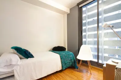 a boy laying on a bed in a room with a window at Apartment Barcelona Rentals - Park Güell Apartments in Barcelona