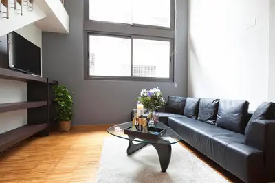 a living room with a black couch and a glass table at Apartment Barcelona Rentals - Park Güell Apartments in Barcelona