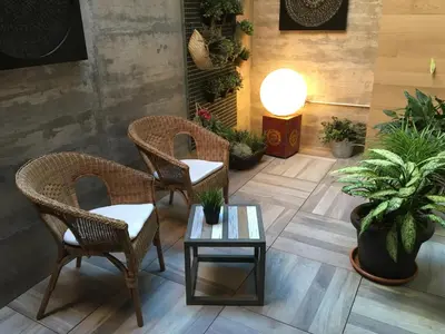 a lobby with wicker chairs and a table and potted plants at Hotel Calabria in La Garriga
