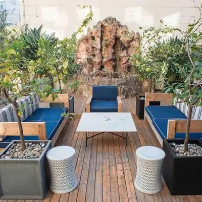 a patio with benches and potted plants and a table at Praktik Rambla in Barcelona
