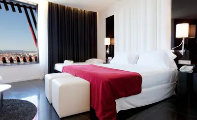 a bedroom with a large white bed with a red blanket at Hotel Porta Fira 4* Sup in Hospitalet de Llobregat