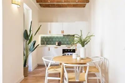 a small kitchen with a wooden table and chairs at Diagonal Apartments by Olala Homes in Barcelona