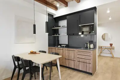 a kitchen with a wooden table and a dining room at Diagonal Apartments by Olala Homes in Barcelona