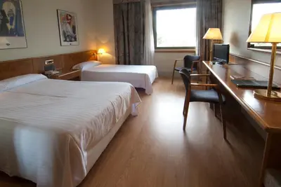 a hotel room with two beds and a desk at Hotel Domo in Vilafranca del Penedès