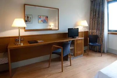 a hotel room with a desk with a television at Hotel Domo in Vilafranca del Penedès