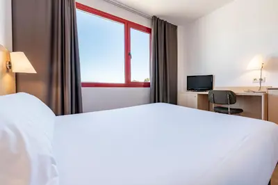 a hotel room with a large bed and a window at Hotel Basic in Vilafranca del Penedès