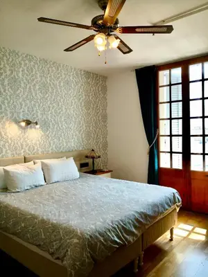 a bedroom with a bed with a ceiling fan at Privat Hotel Liberty Sitges in Sitges