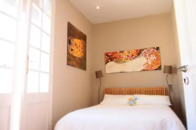 a bedroom with a bed and two paintings on the wall at Privat Hotel Liberty Sitges in Sitges
