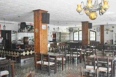 a restaurant with tables and chairs and a bar at Raco d'en Pepe in Calella