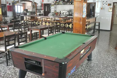 a pool table in a room with tables and chairs at Raco d'en Pepe in Calella
