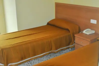 a bedroom with a bed with a phone on a table at Raco d'en Pepe in Calella