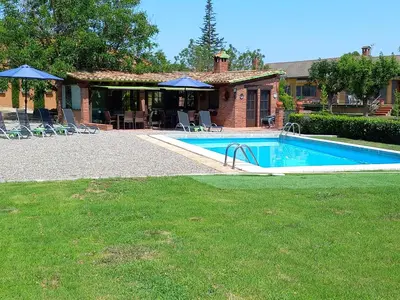 a swimming pool in front of a house at Finca La Pedrera in Capellades