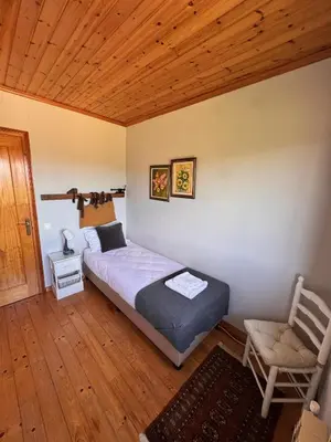 a bedroom with a bed and a chair in it at Finca La Pedrera in Capellades