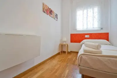 a small room with two beds and a window at Comfortable 4 rooms 2Bath w balcony in Barcelona