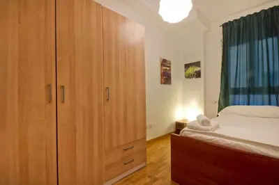 a bedroom with a large wooden cabinet next to a bed at Comfortable 4 rooms 2Bath w balcony in Barcelona