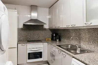 a kitchen with white cabinets and a sink at Comfortable 4 rooms 2Bath w balcony in Barcelona
