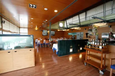 a restaurant with a dining room with tables and a bar at Hotel Granollers in Granollers