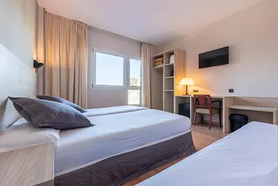 a hotel room with two beds and a desk at Hotel Air Penedès in Vilafranca del Penedès