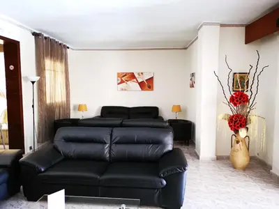 a living room with a black leather couch and a table at Hostal Bonavista in Calella