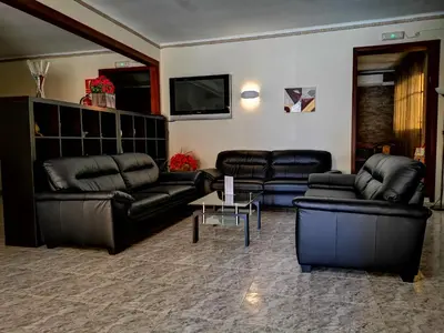 a living room with leather furniture and a flat screen tv at Hostal Bonavista in Calella