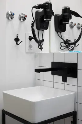 a bathroom with a sink and two phones on the wall at Bailén Green House in Barcelona