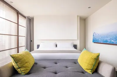 a bedroom with a bed and a couch with yellow pillows at Sixtytwo Hotel in Barcelona