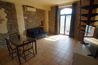 a living room with a blue couch and a table at Urbi Apartments in Manresa